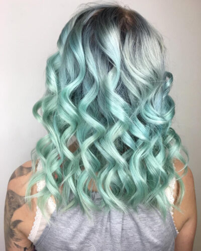 hair of a girl with gray-based waves and mint-colored strands 