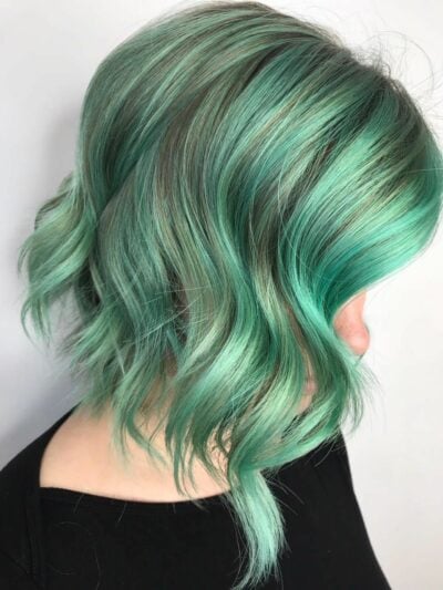 chica mostrando su cabello con ondas en color menta 