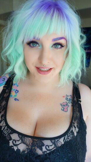 photograph of a girl with mint hair color with a purple streak 