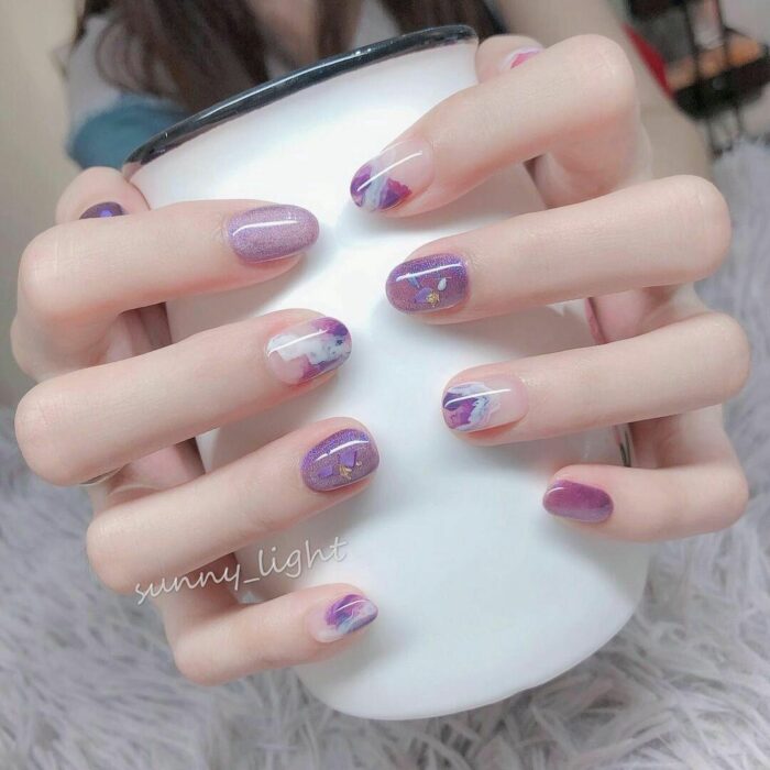 lilac acrylic nails with glitter on several nails 