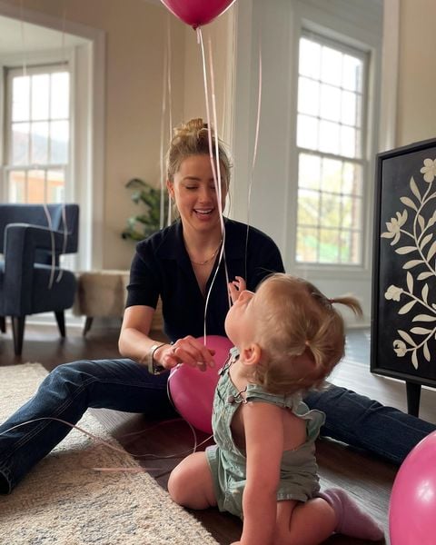 Amber Heard amarrando unos globos para su pequeña hija Paige