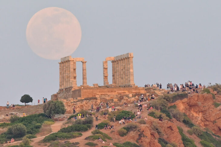 La «Luna de las Flores» se eleva detrás del Templo de Poseidón, en el Cabo Sounion, el 15 de mayo de 2022 en Atenas, Grecia