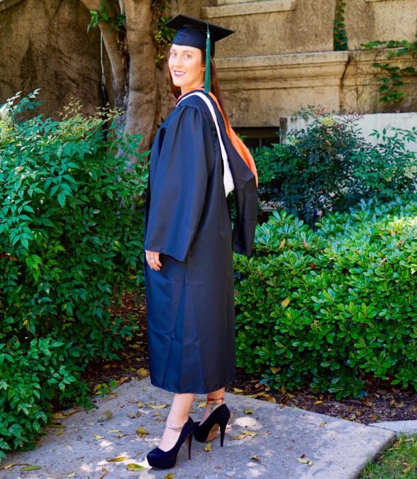 Fotografía de una chica posando con birrete y toga de graduación 