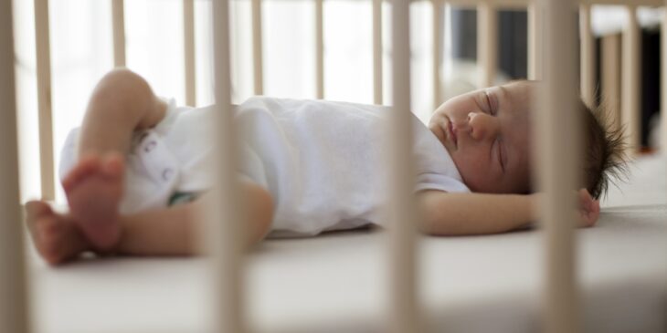 Sleeping newborn baby inside a crib 