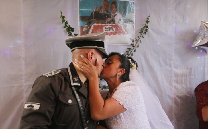 pareja que celebró su boda nazi dándose un beso en su fiesta