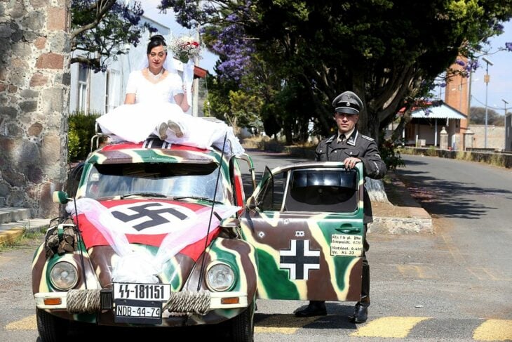 Pareja de esposos junto a su carro Volkswagen pintado con símbolos Nazis 