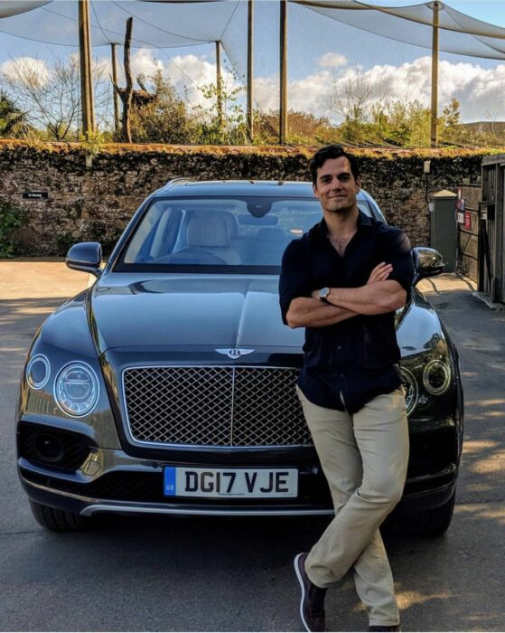 Henry Cavill posando frente a un auto 