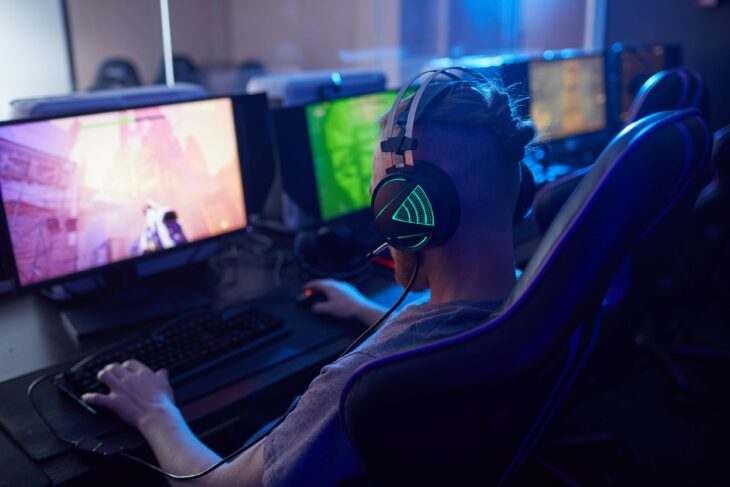 hombre jugando videojuegos frente a una computadora 