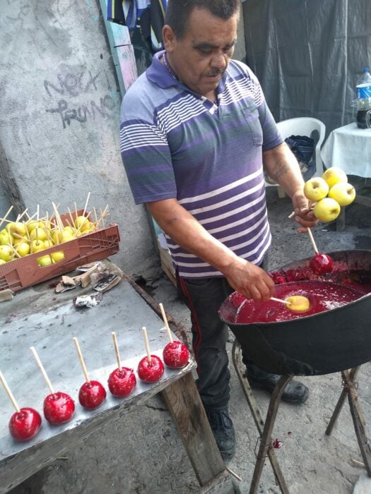 Hombre preparando manzanas con caramelo 