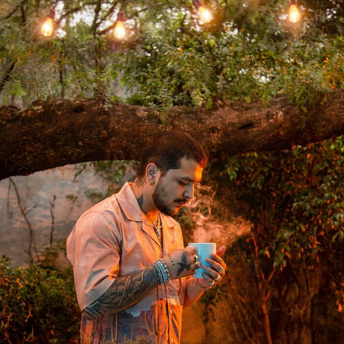 Photograph of Christian Nodal blowing into a cup 