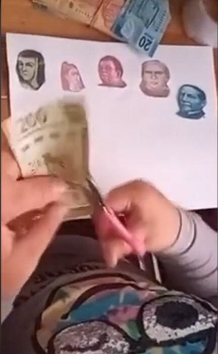 manos de una persona quitándole billetes mexicanos a una niña 