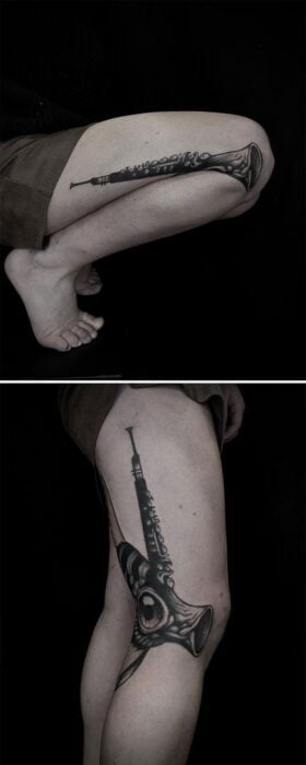 tatuaje de clarinete en una pierna que al desdoblar se forma un pez 
