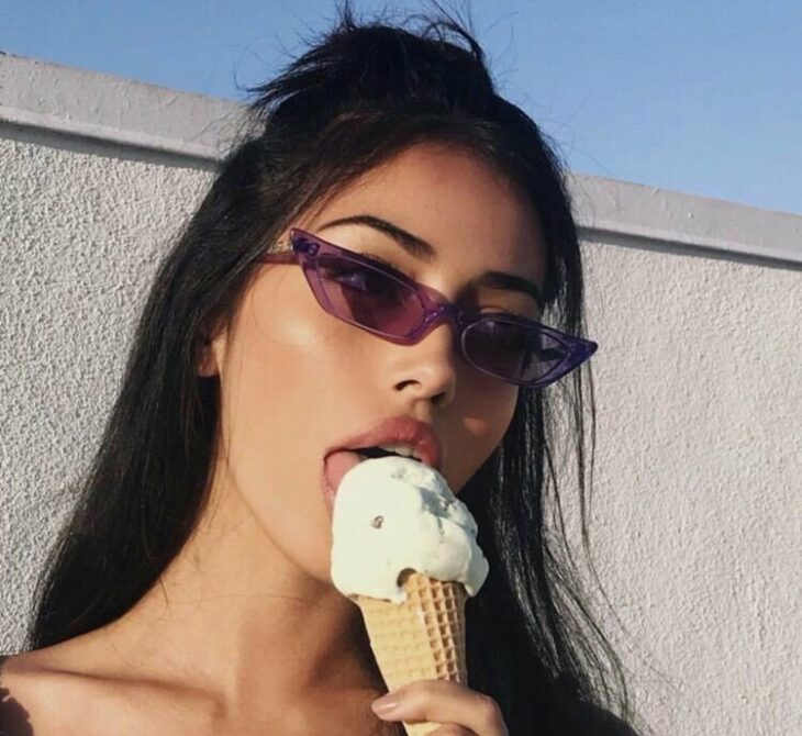 foto de una chica comiendo un helado usando lentes de sol morados y delgados 