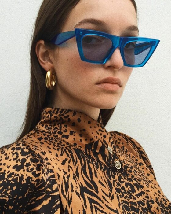 fotografía de una mujer usando lentes gruesos de color azul 