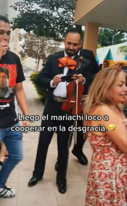 mariachis rodeados de gente en una fiesta 