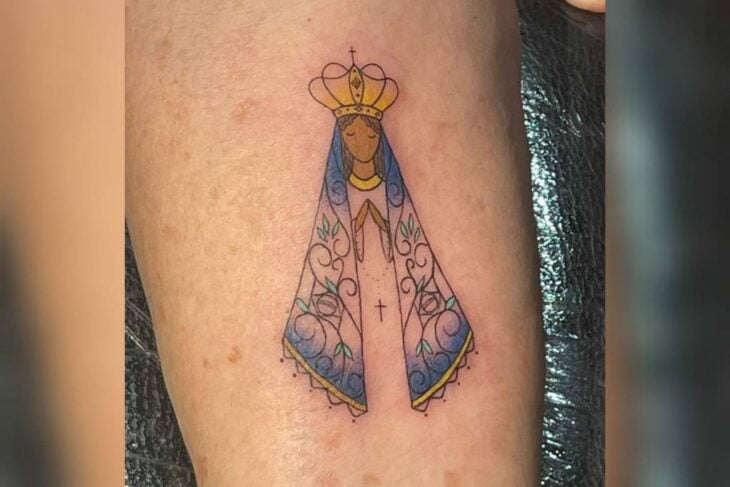 tatuaje de una virgen en el antebrazo de una abuelita