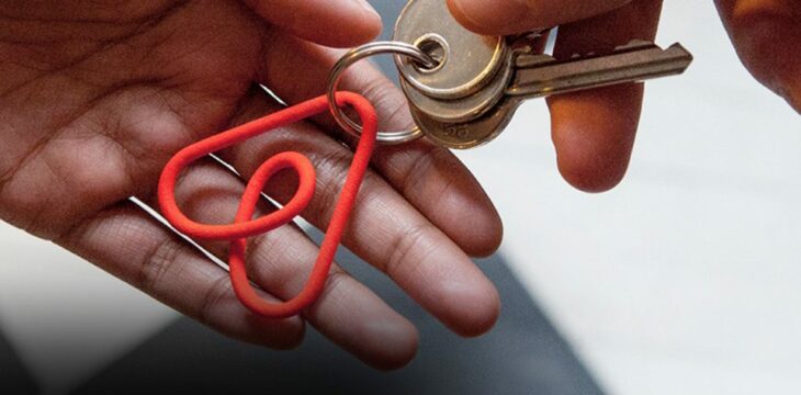 manos dando una copia de llaves con el logo de Airbnb