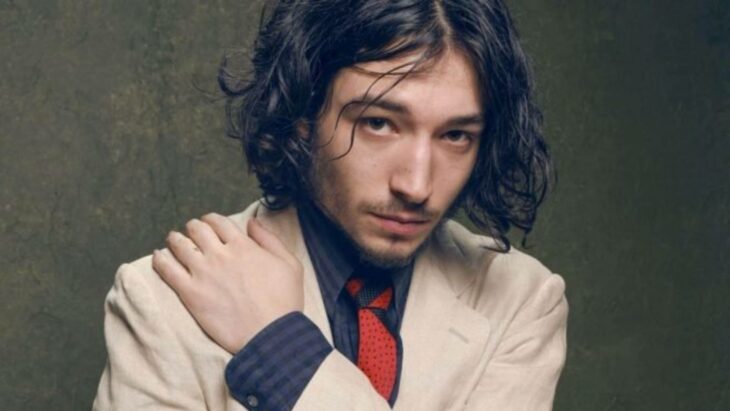 Ezra Miller posando con un traje color blanco 