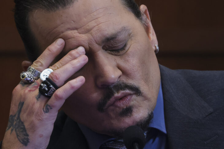 Actor Johnny Depp agarrando su cara 