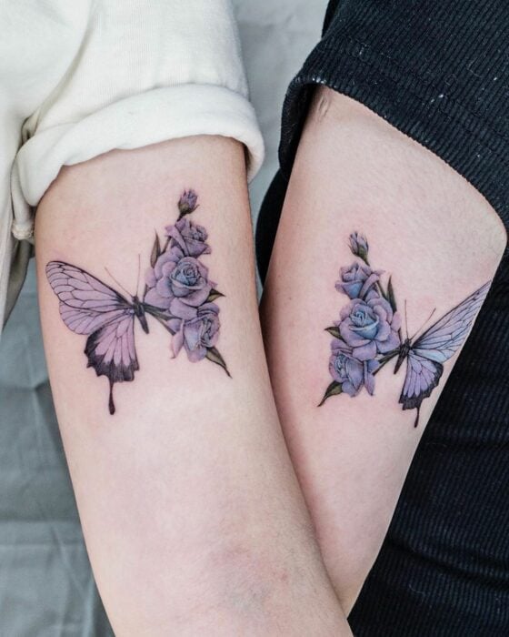 dos brazos de unas chicas con el mismo diseño de tatuaje de mariposa en color morado 