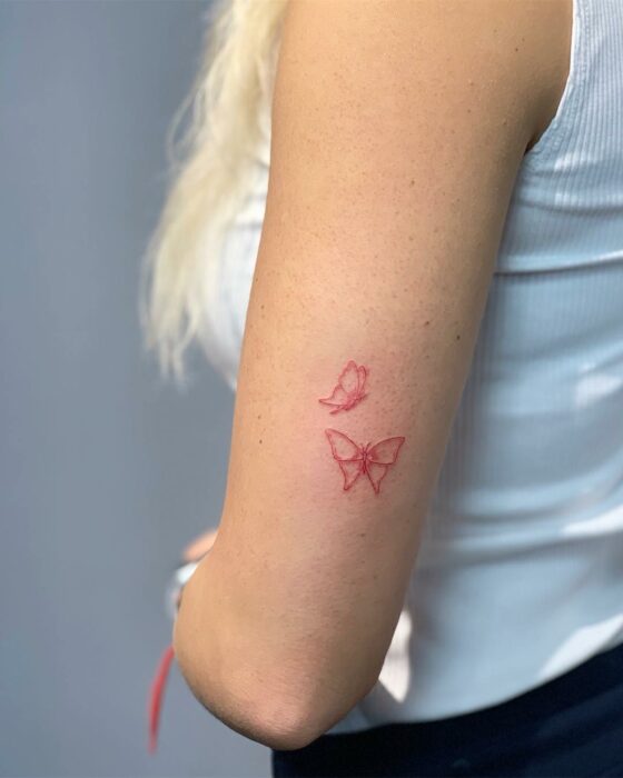 tatuajes de mariposa roja en el brazo de una chica 