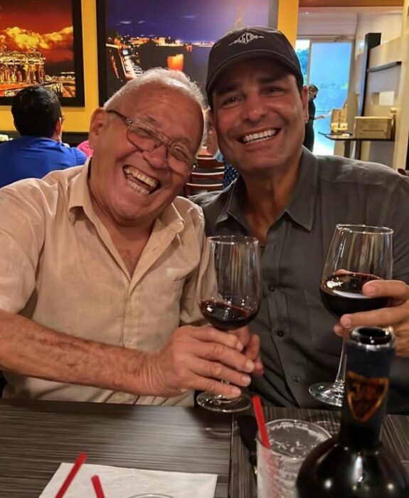 Fotografía del cantante Chayanne con una copa de vino a lado de su padre 