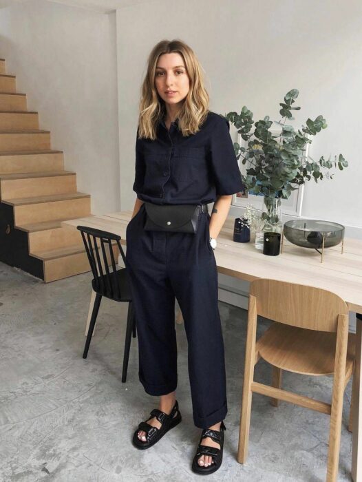 mujer posando frente a un comedor a lado de unas escaleras dentro de una casa 