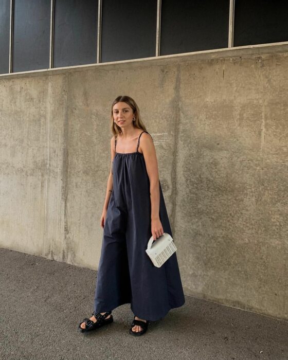 woman wearing plain sleeveless jumpsuit posing in the street 