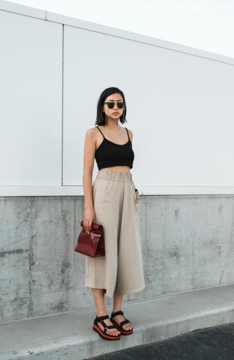 girl posing with a crop top with loose straight pants standing on a street 