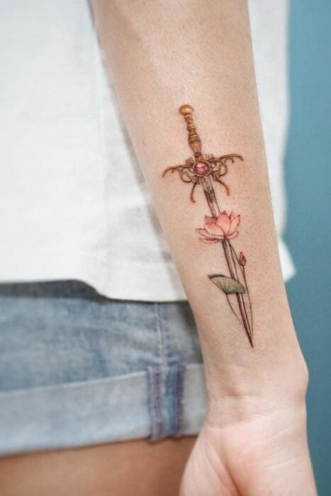 espada con flore de loto ;Tatuajes de espadas para sacar a tu guerrera mágica interna