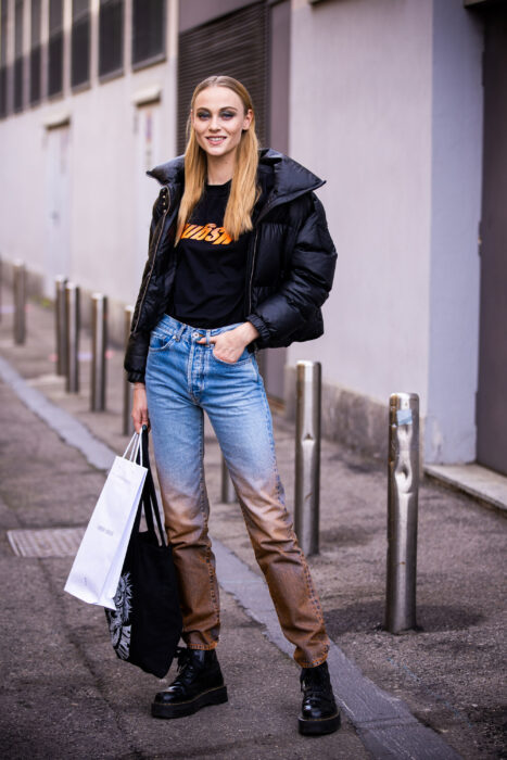 chica posando para mostrar su look en medio de un callejón 