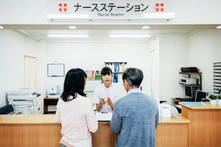 Enfermera hablando con pareja en hospital japonés