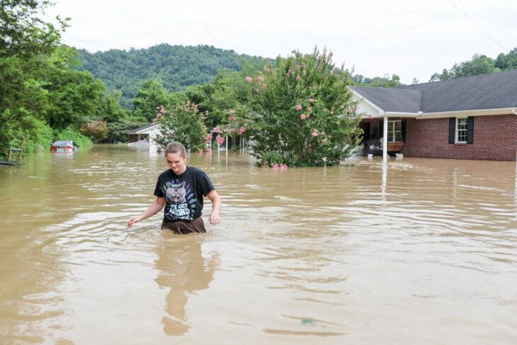 joven caminando entre la inundación