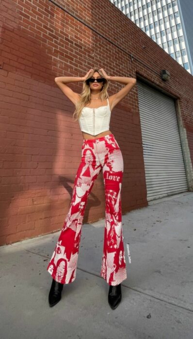 chica con las manos en la cabeza posando unos jeans rojos con blanco 