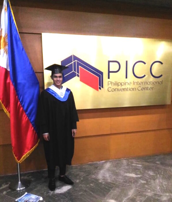 imagen de un chico posando con su toga recién graduado 