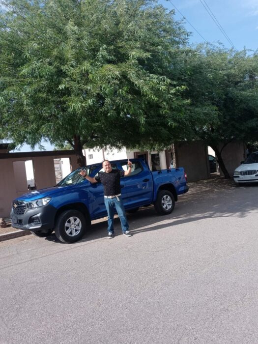 profesor de primaria de Christian Nodal posando frente a la camioneta que le regaló como promesa de la infancia 