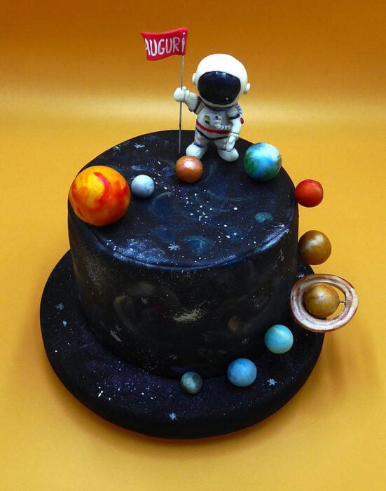 pastel galáctico con algunos planetas y un astronauta encima 