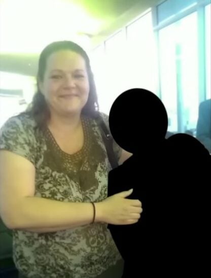 Mujer abrazando a su hijo quien por seguridad fue tapado en color negro