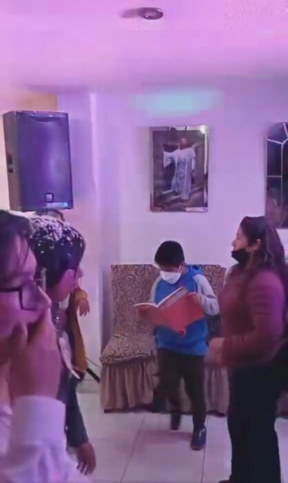 Niño leyendo un libro mientras baila en una fiesta