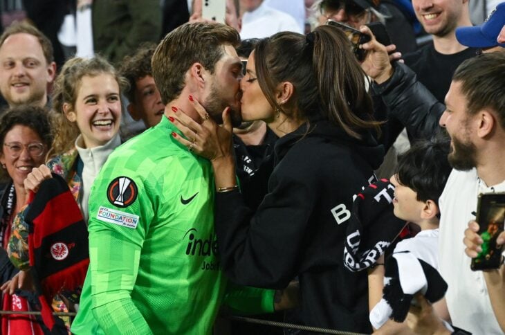 mujer besando a un portero dentro de un estadio de futbol