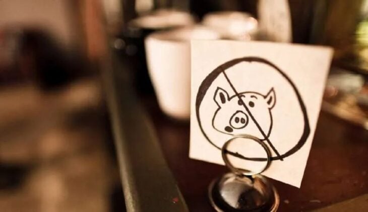 hoja con un dibujo de un cerdo prohibido en una mesa de un restaurante 