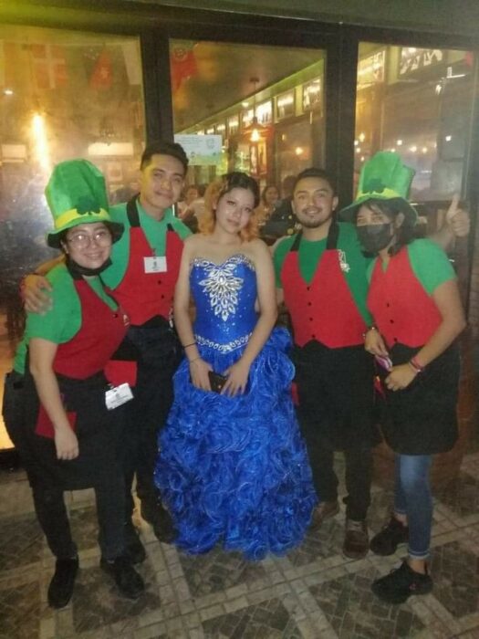 quinceañera rodeada de meseros que le celebraron su cumpleaños en Quintana Roo