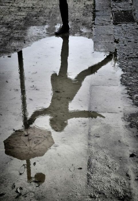 reflection of a woman in a puddle