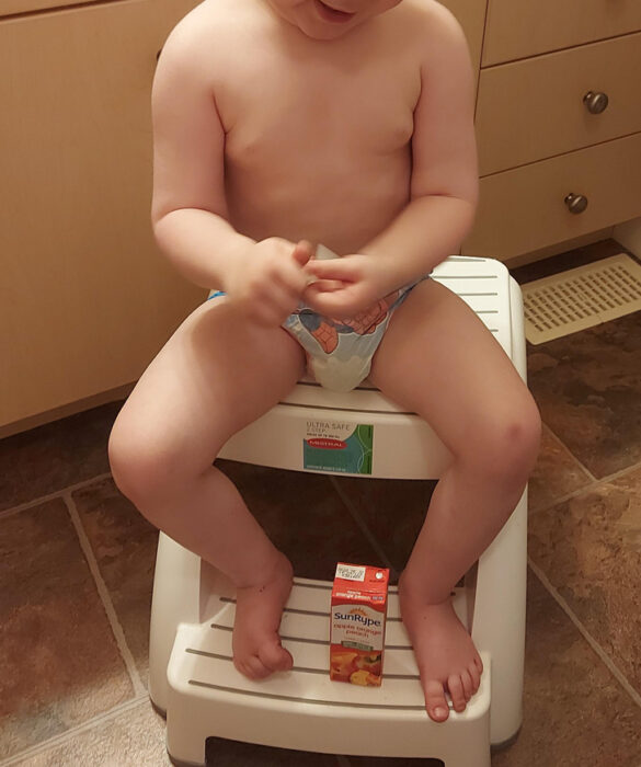 boy sitting on a bench with his juice