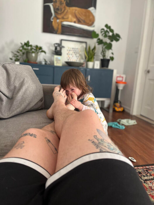 girl smelling her dad's feet