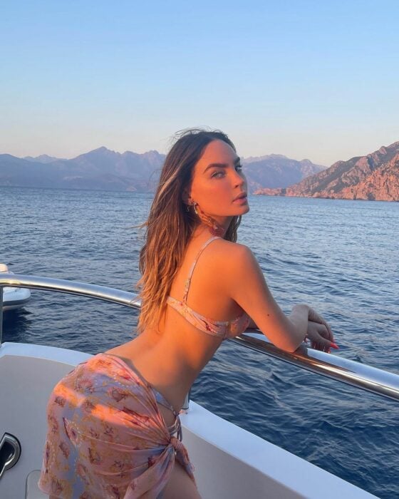 Belinda posando en bikini en un yate sobre una playa en Italia 