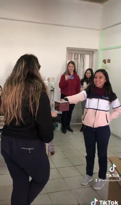 chica entregando un regalo a una compañera de su salón 