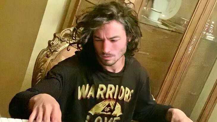 Foto del actor Ezra Miller sentado en una silla en lo que parece ser una sala de estar 