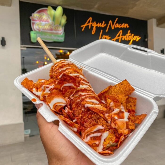 imagen de un elote preparado frente a un local donde los venden 