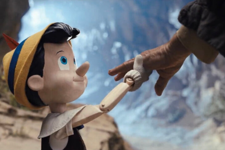 Image of Pinocchio Live action grabbing Tom Hanks hand 